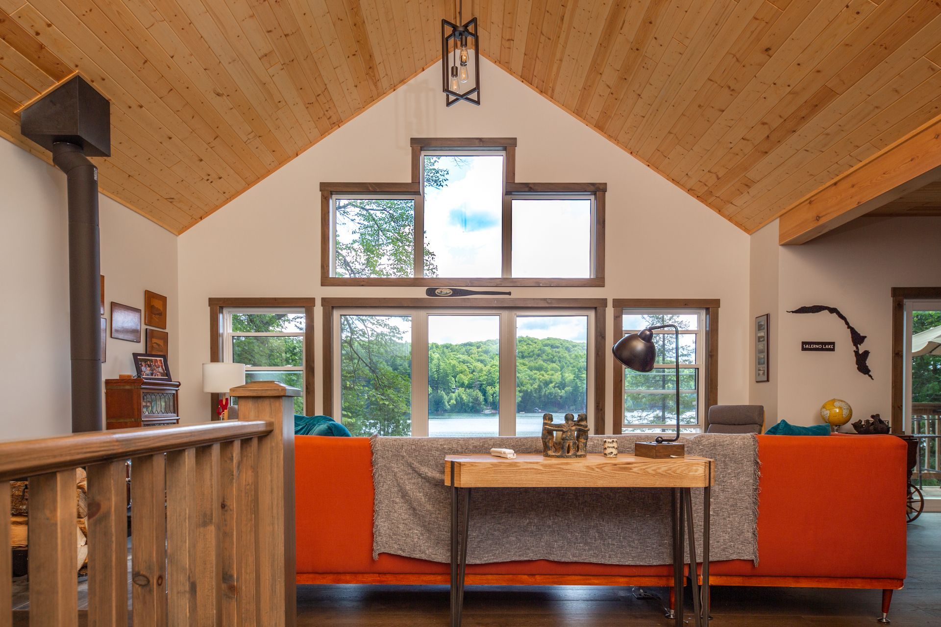A living room with a vaulted ceiling and lots of windows