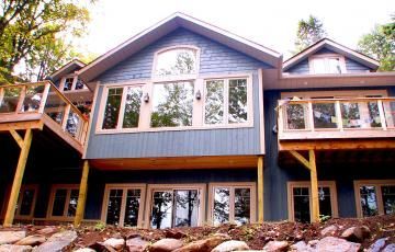 A large house with a lot of windows and a large deck
