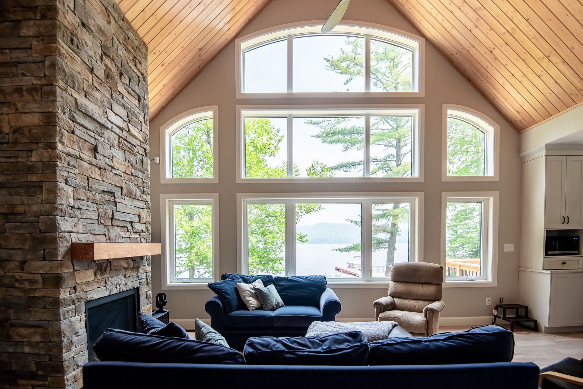 A living room with a lot of windows and a fireplace.