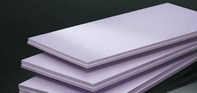 Three purple sheets of styrofoam are stacked on top of each other on a table.