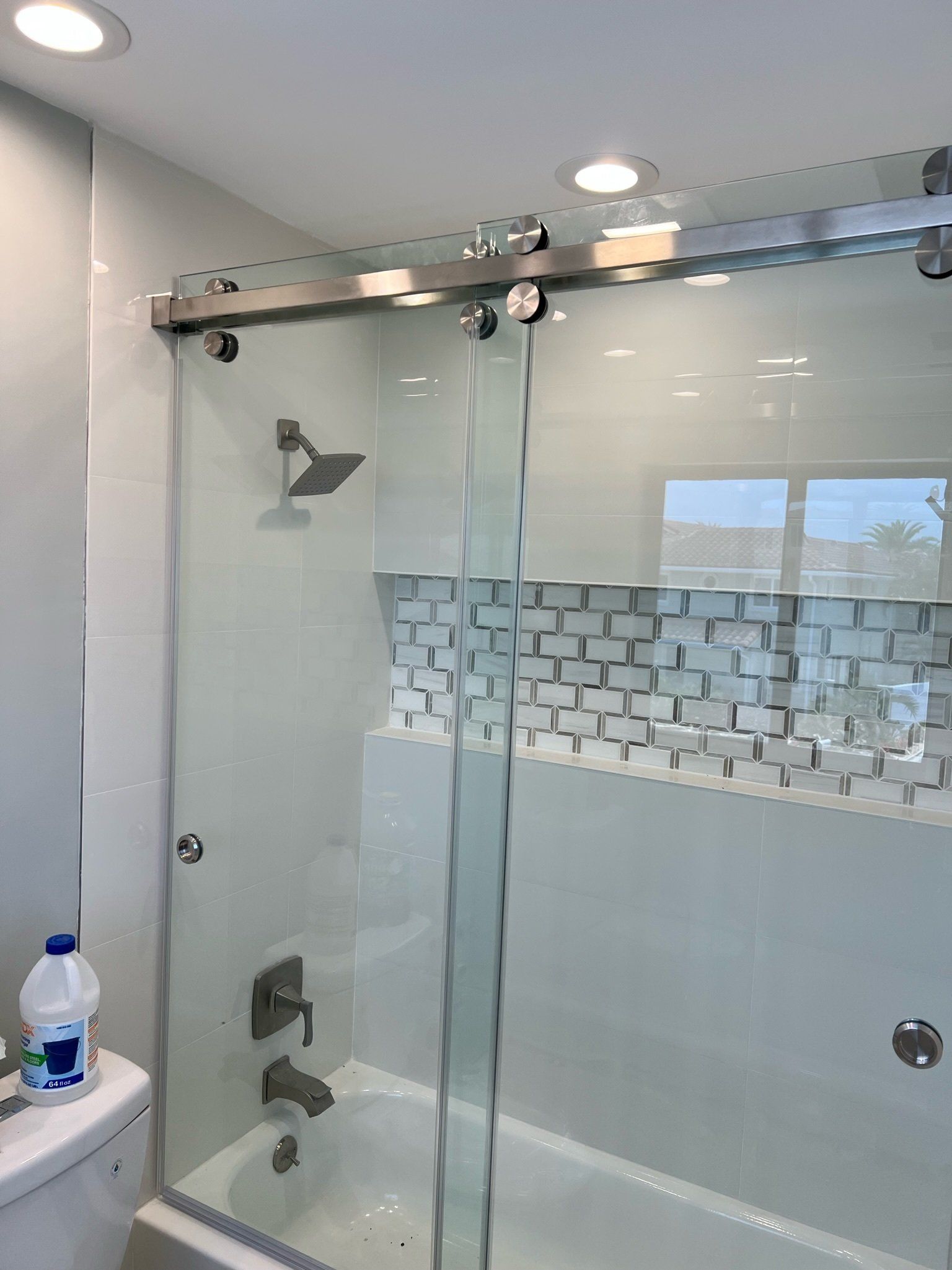 by-pass frameless shower door installed in bathroom