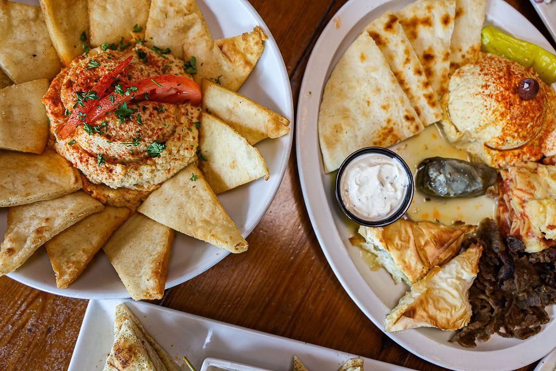 Two plates of food are sitting on a wooden table.