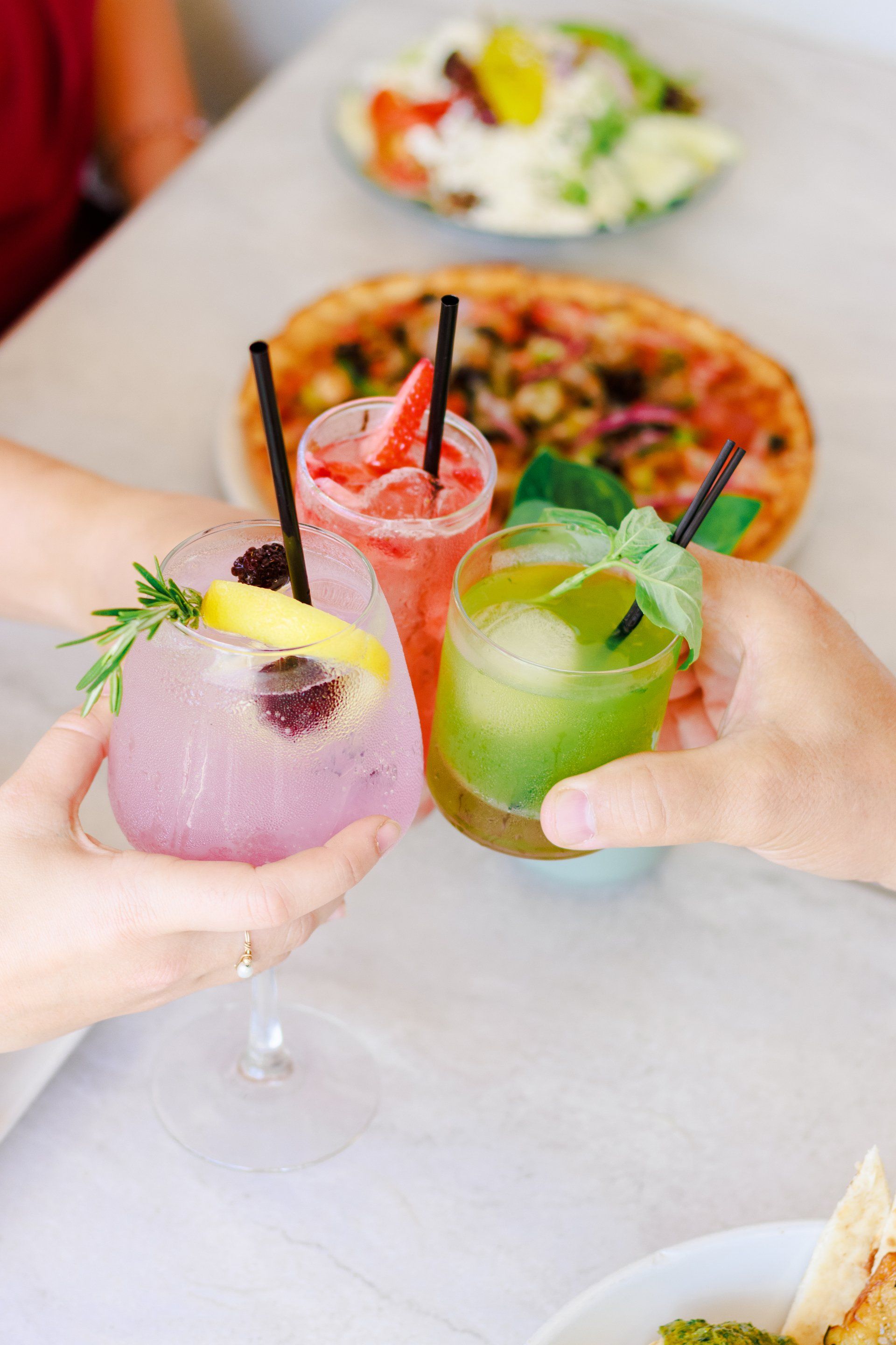 A group of people are toasting with drinks at a table.