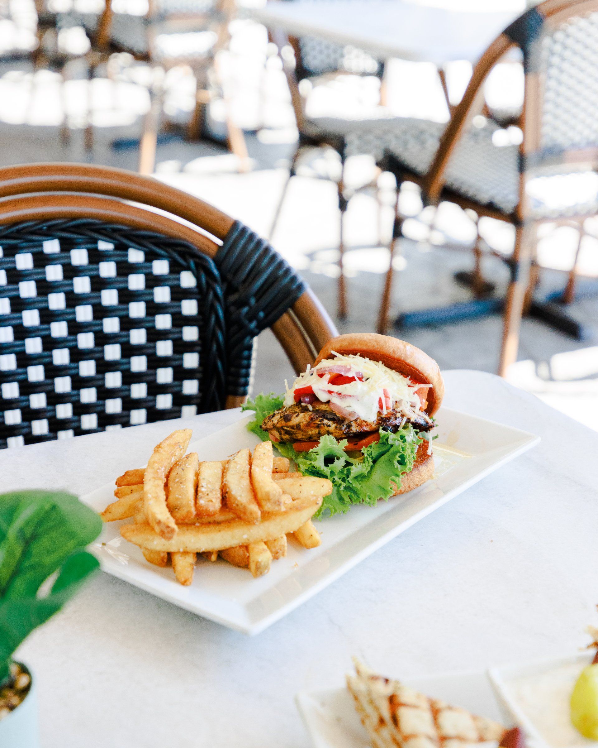A hamburger and french fries on a white plate on a table