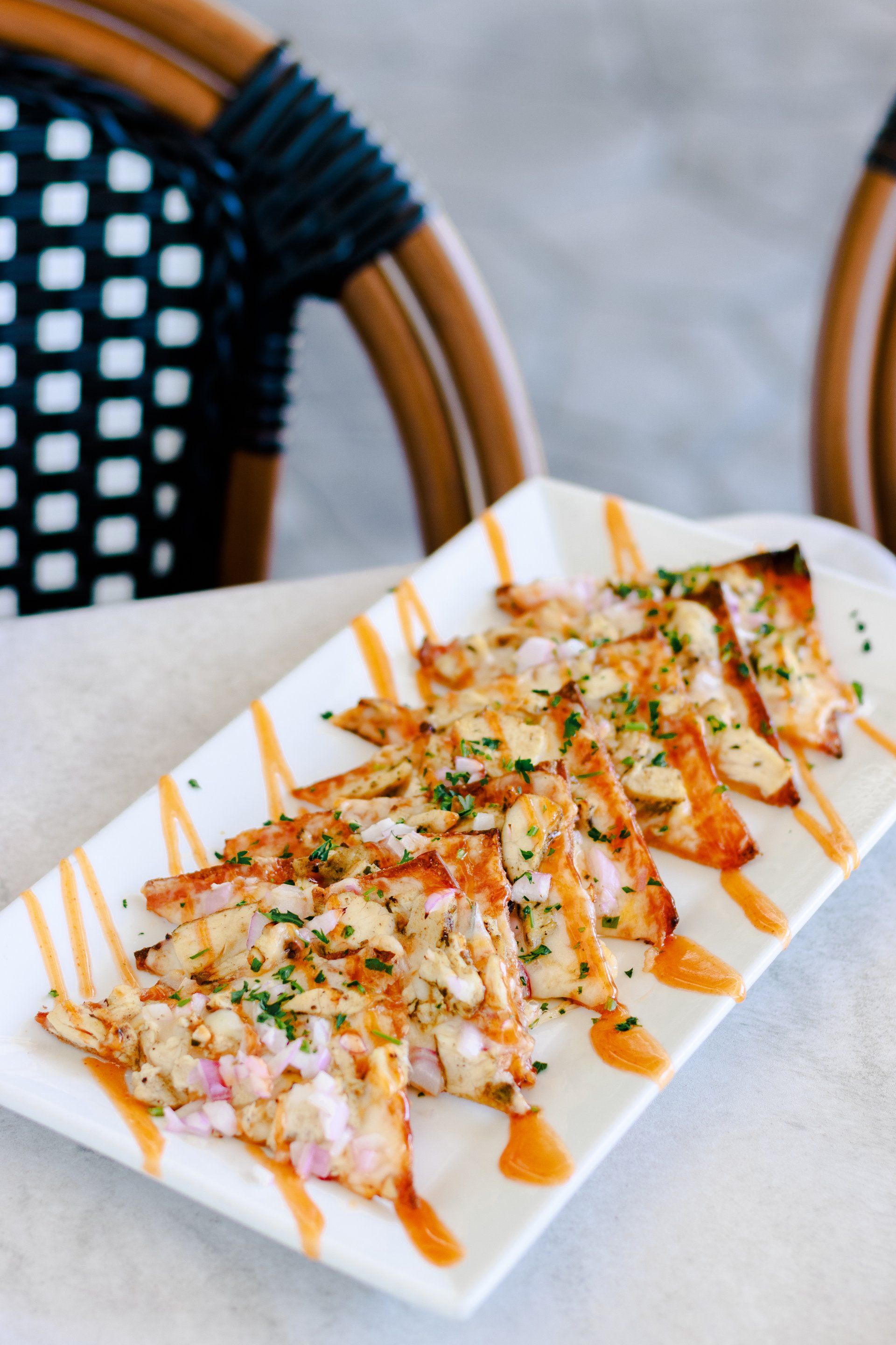 A white plate topped with slices of pizza on a table.
