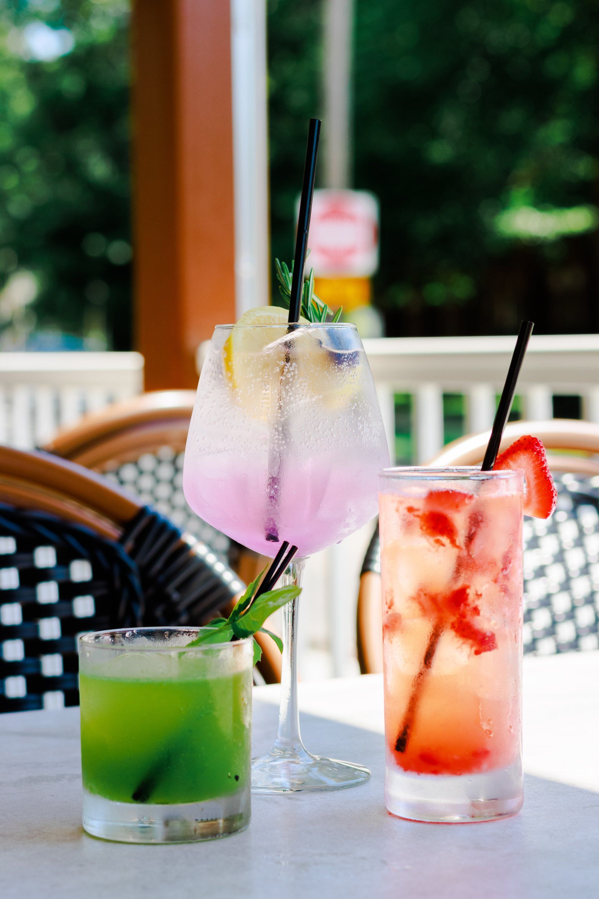 Three different colored drinks are sitting on a table.