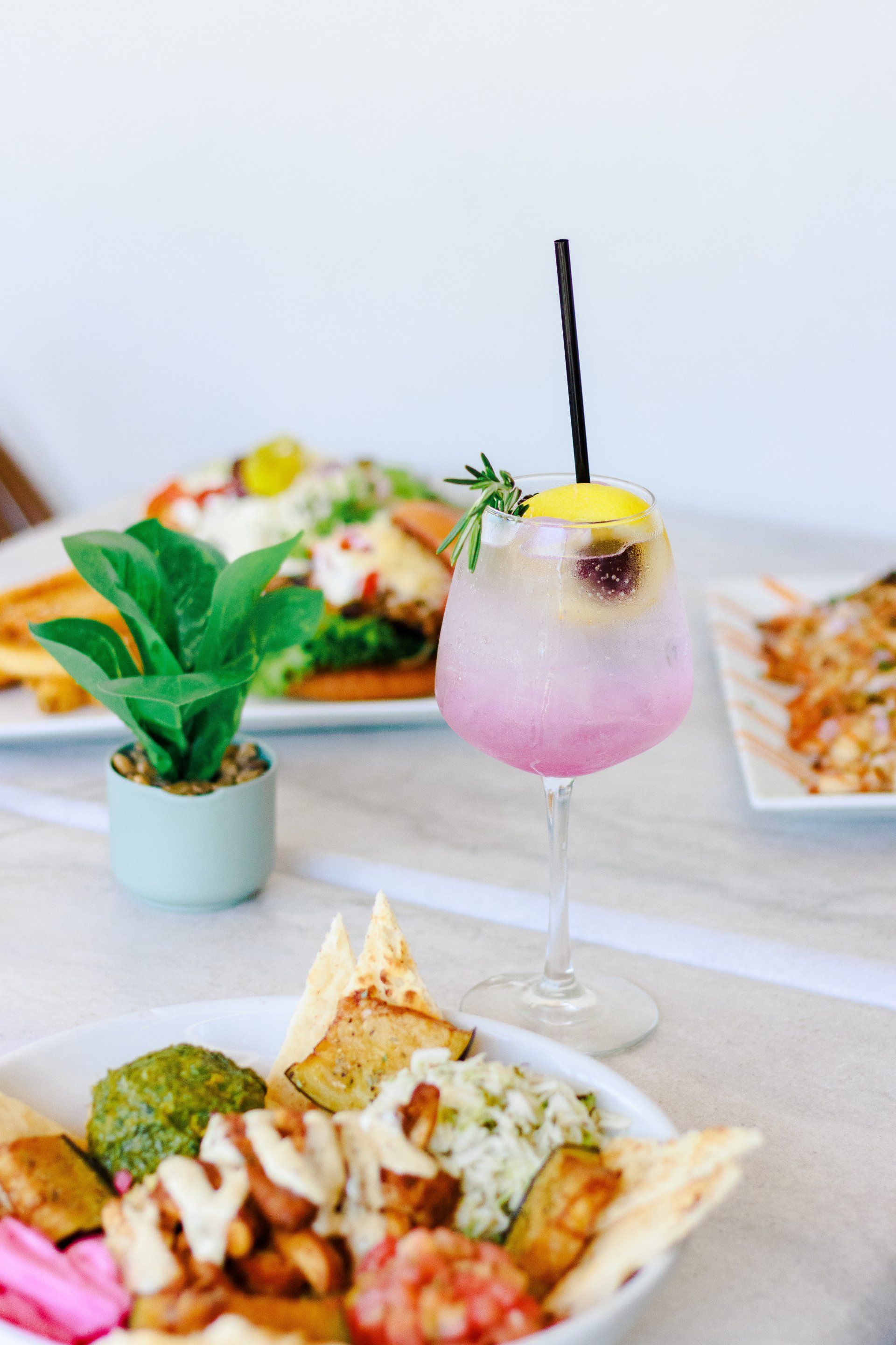 A table topped with plates of food and a drink.