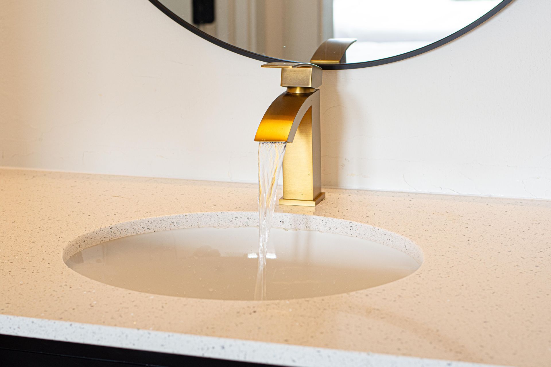white marble sink with gold faucet
