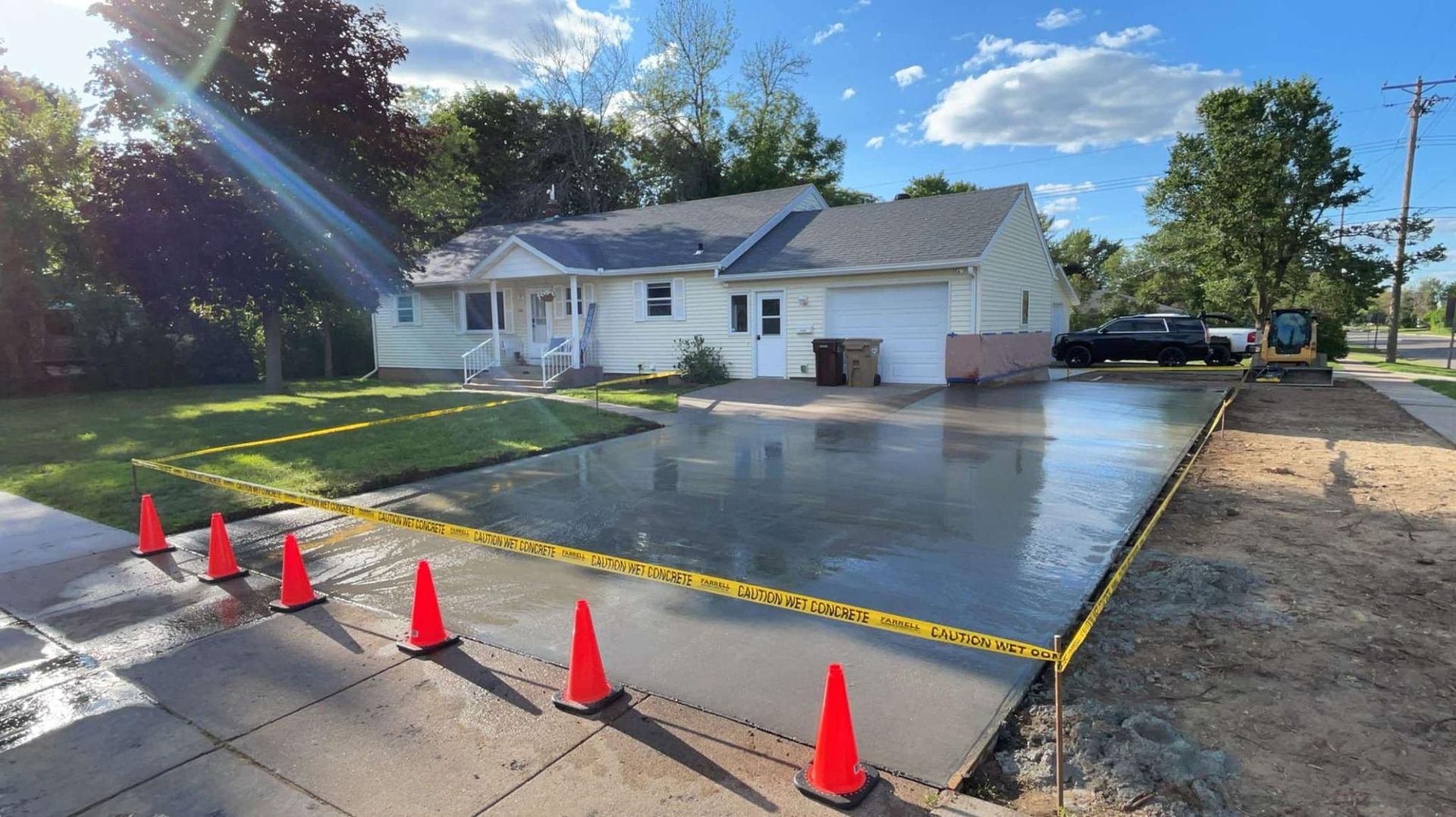 Picture of a big yard in front a house just finished sealing in concrete.