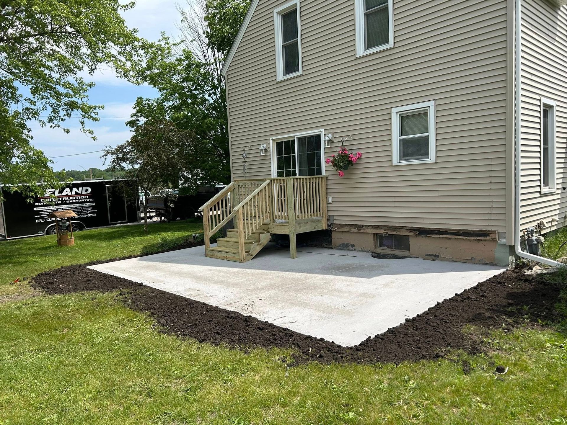 Picture of a concrete patio pad added to a house. You can see a backyard concrete patio that was just put in.