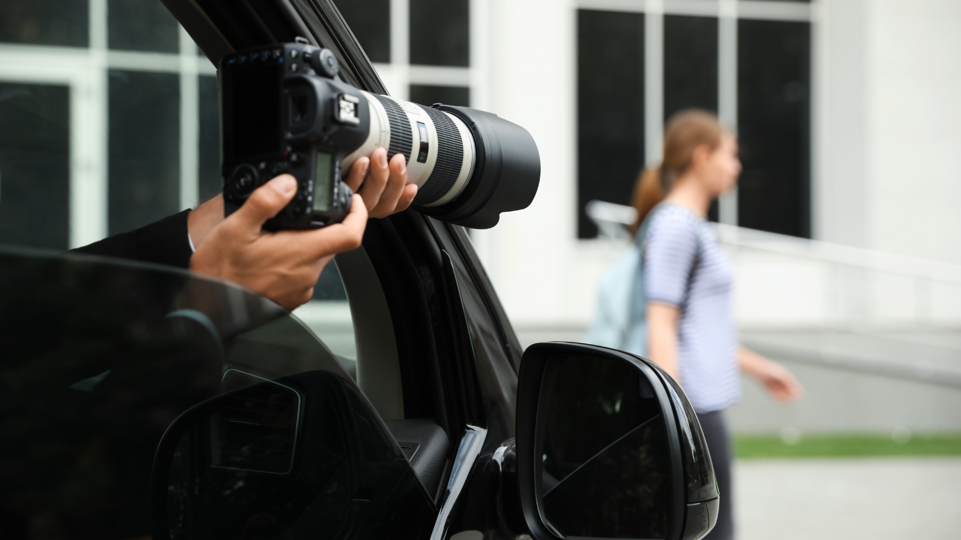 A man is taking a picture of a woman with a camera from the window of a car.