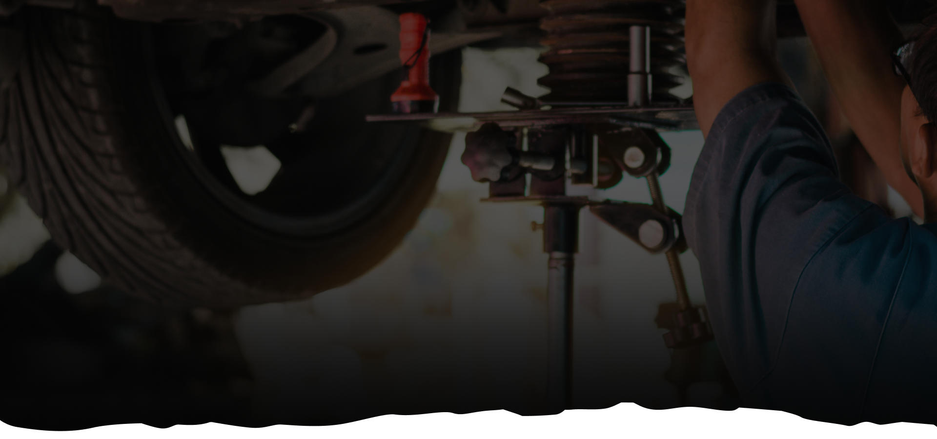 A man is working on a car in a garage. | Mark's Auto Repair