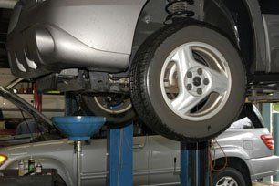 A car is sitting on a lift in a garage. | Mark's Auto Repair