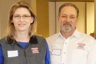 A man and a woman are standing next to each other in a room. | Mark's Auto Repair