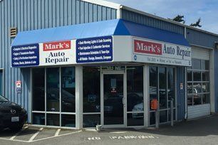 A car is parked in front of a mark 's auto repair shop. | Mark's Auto Repair