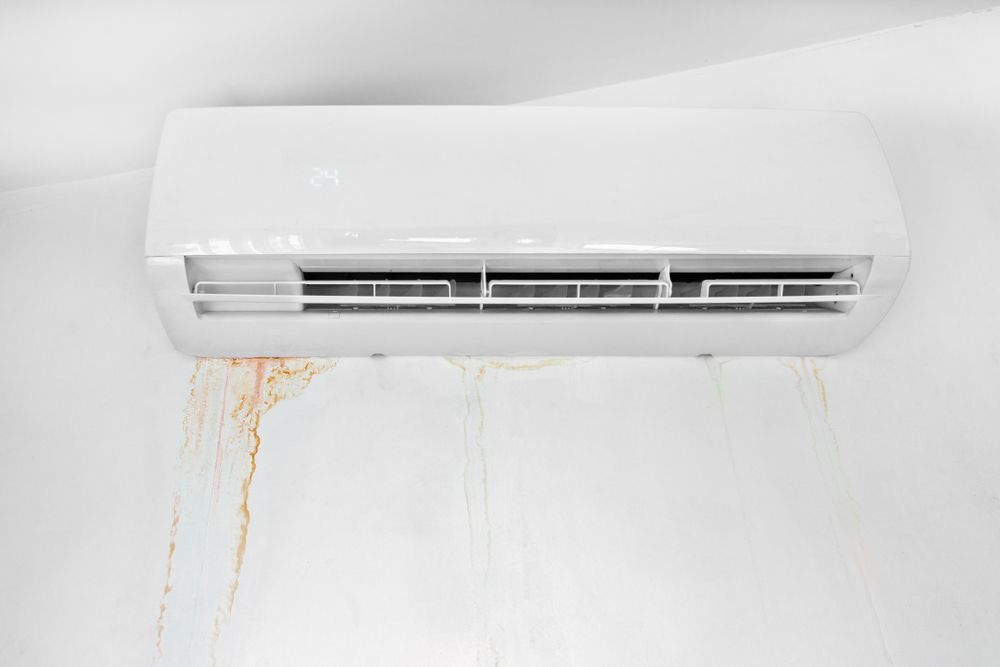 A White Air Conditioner Is Leaking Water On A White Wall — More Clean Air In Cessnock, NSW