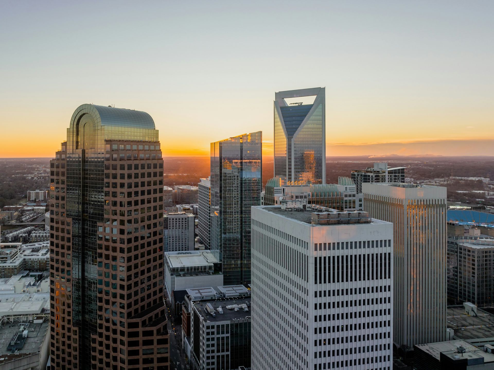 Charlotte, North Carolina skyline at sunset, golden light on skyscrapers.