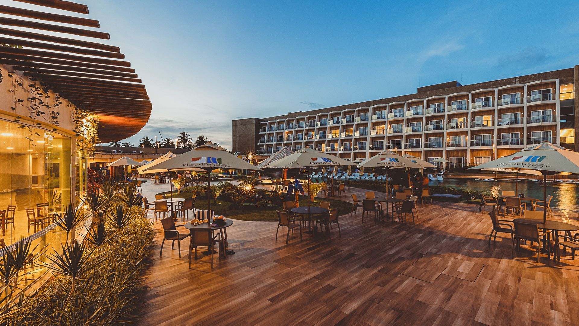 Quarto com vista para o mar, com cama, cadeira e grandes janelas com vista para a praia.