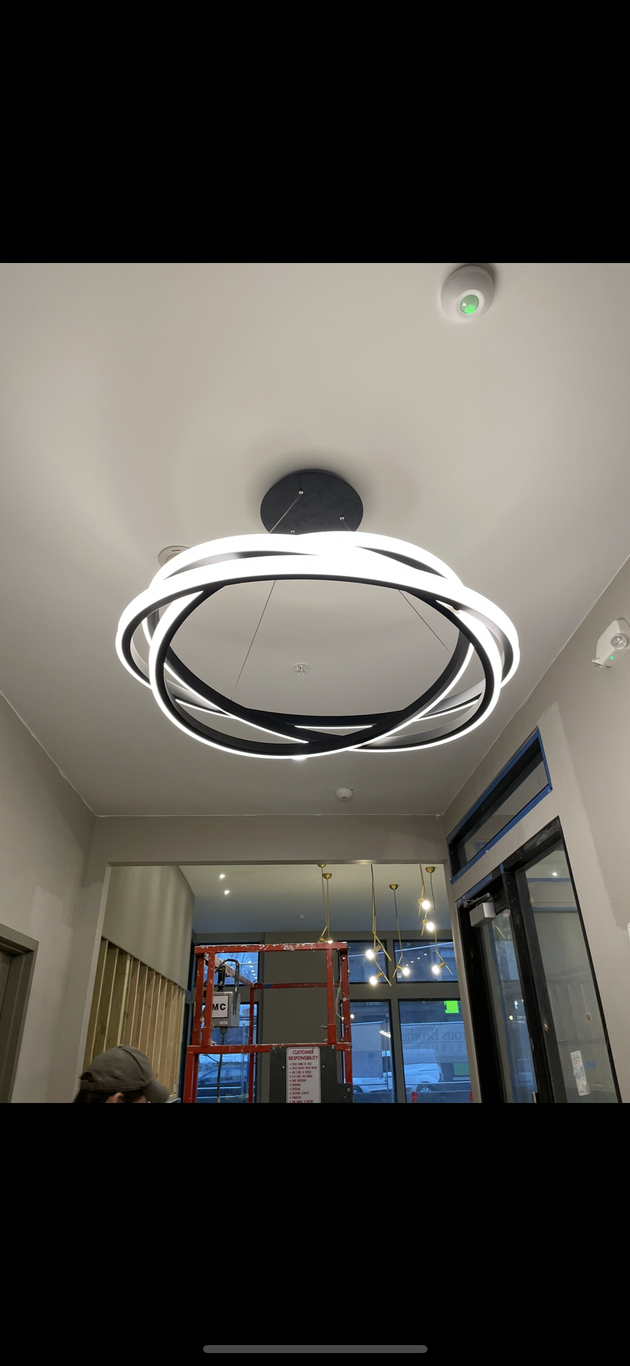 A large circular light fixture is hanging from the ceiling of a room.