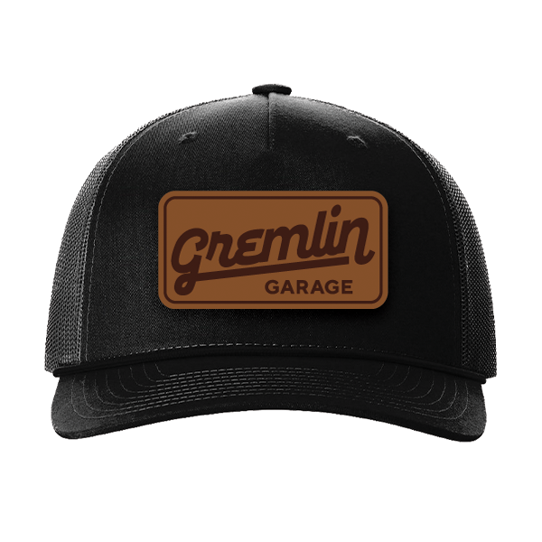 A black hat with a brown patch that says gremlin garage