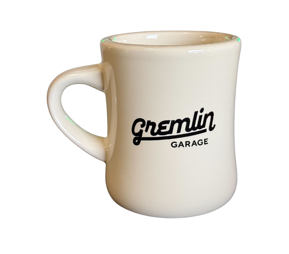 A white coffee mug with the Gremlin Garage Logo