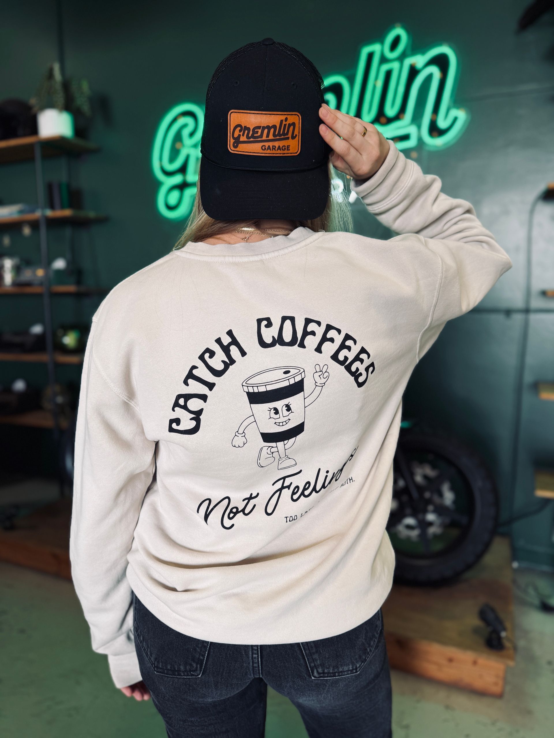 The back of a sweatshirt that says catch coffees not feelings