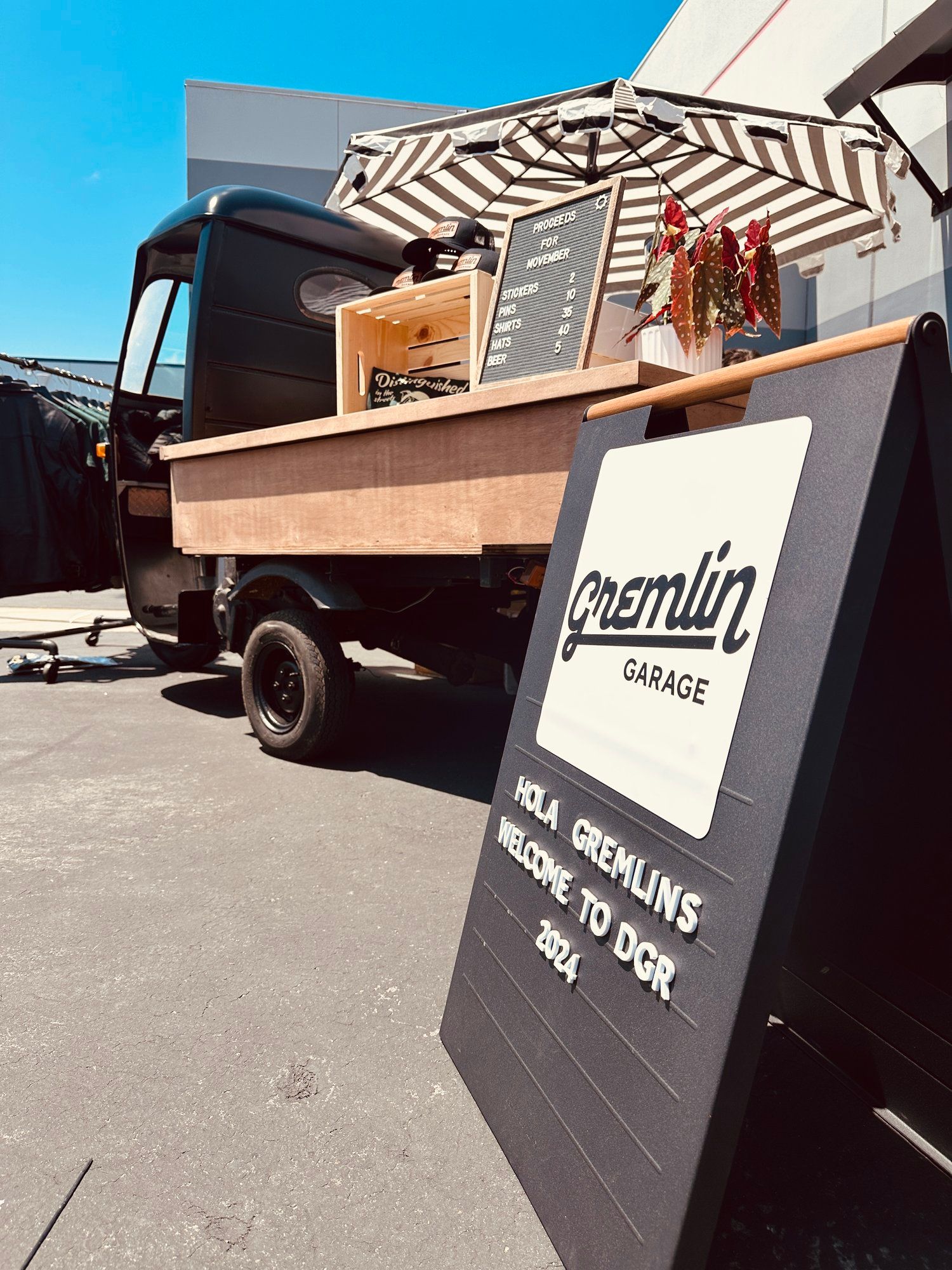 A coffee cart is parked in a parking lot next to a sign.
