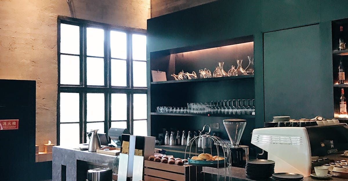 A kitchen with a lot of shelves and a coffee machine.