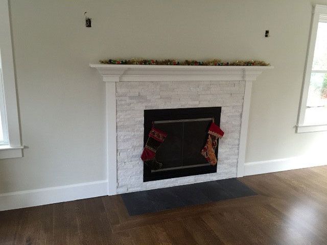 A fireplace with Christmas stockings on it in a living room
