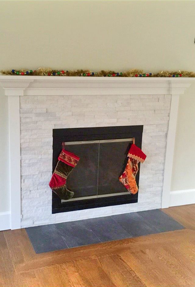 Two Christmas stockings are hanging on a fireplace in a living room