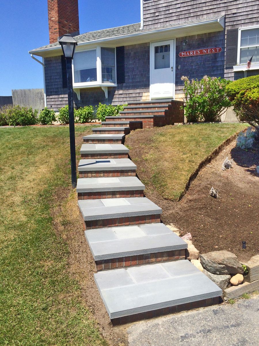 A stone walkway leading to the front of a house
