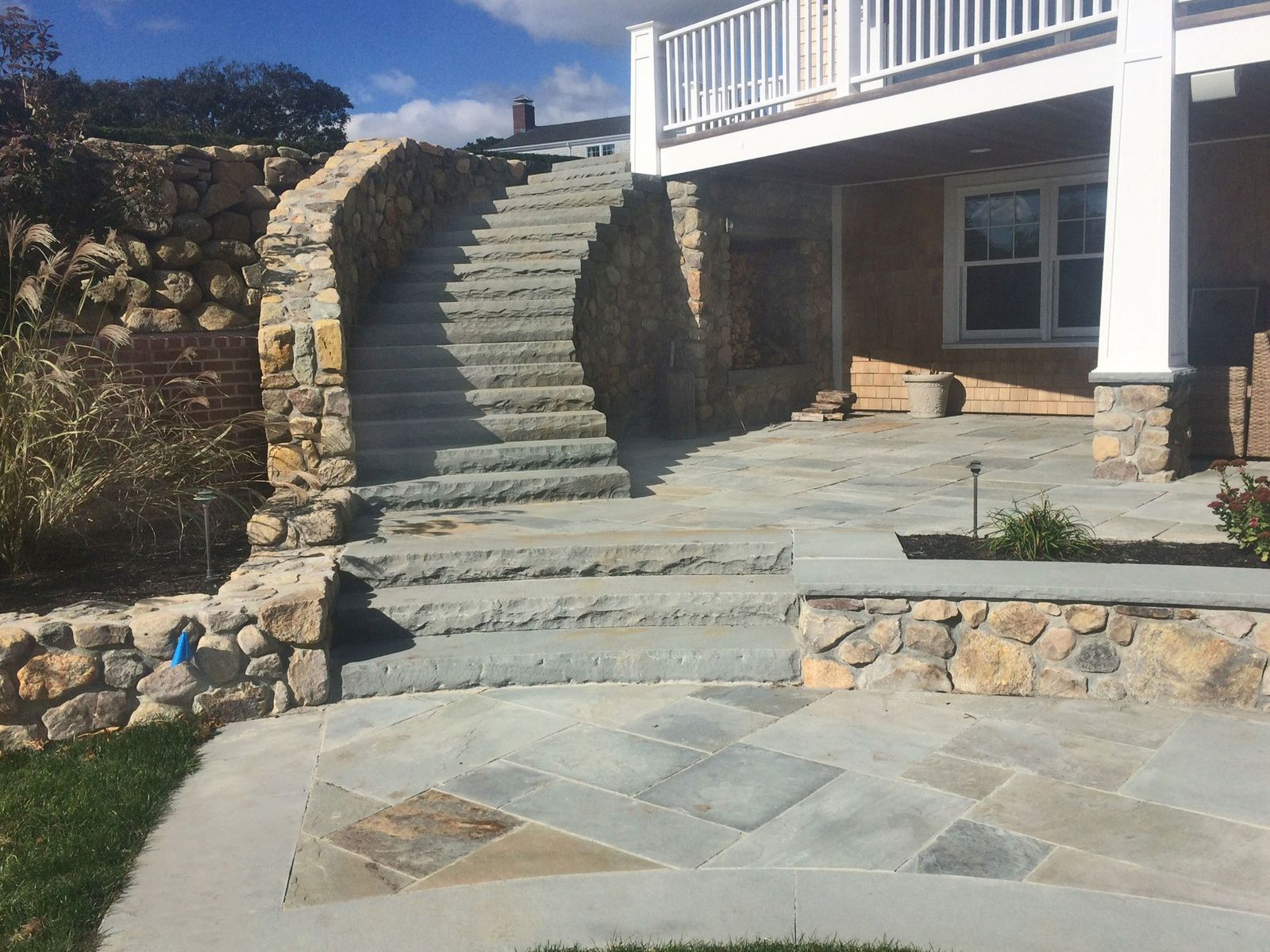 A stone staircase leading up to a house with a white railing