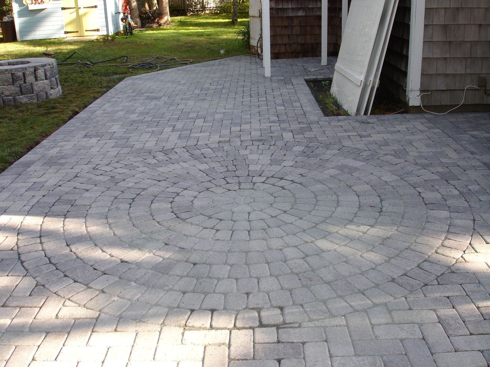 A brick walkway with a circular design in the middle