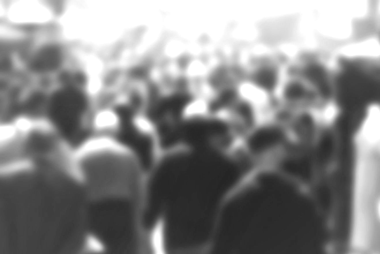 A blurry picture of a crowd of people standing in a room.