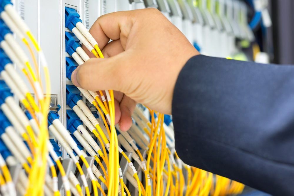 Man Unplugging Cables In Commercial Electrical Circuit Board — Barnes Electrical in Moranbah, QLD