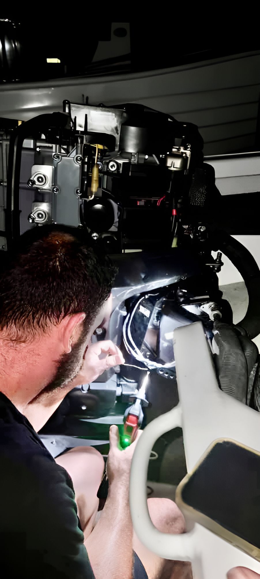 A Man Is Working On A Boat Engine In A Garage — Deri's Mobile Mechanical In Casuarina, NT