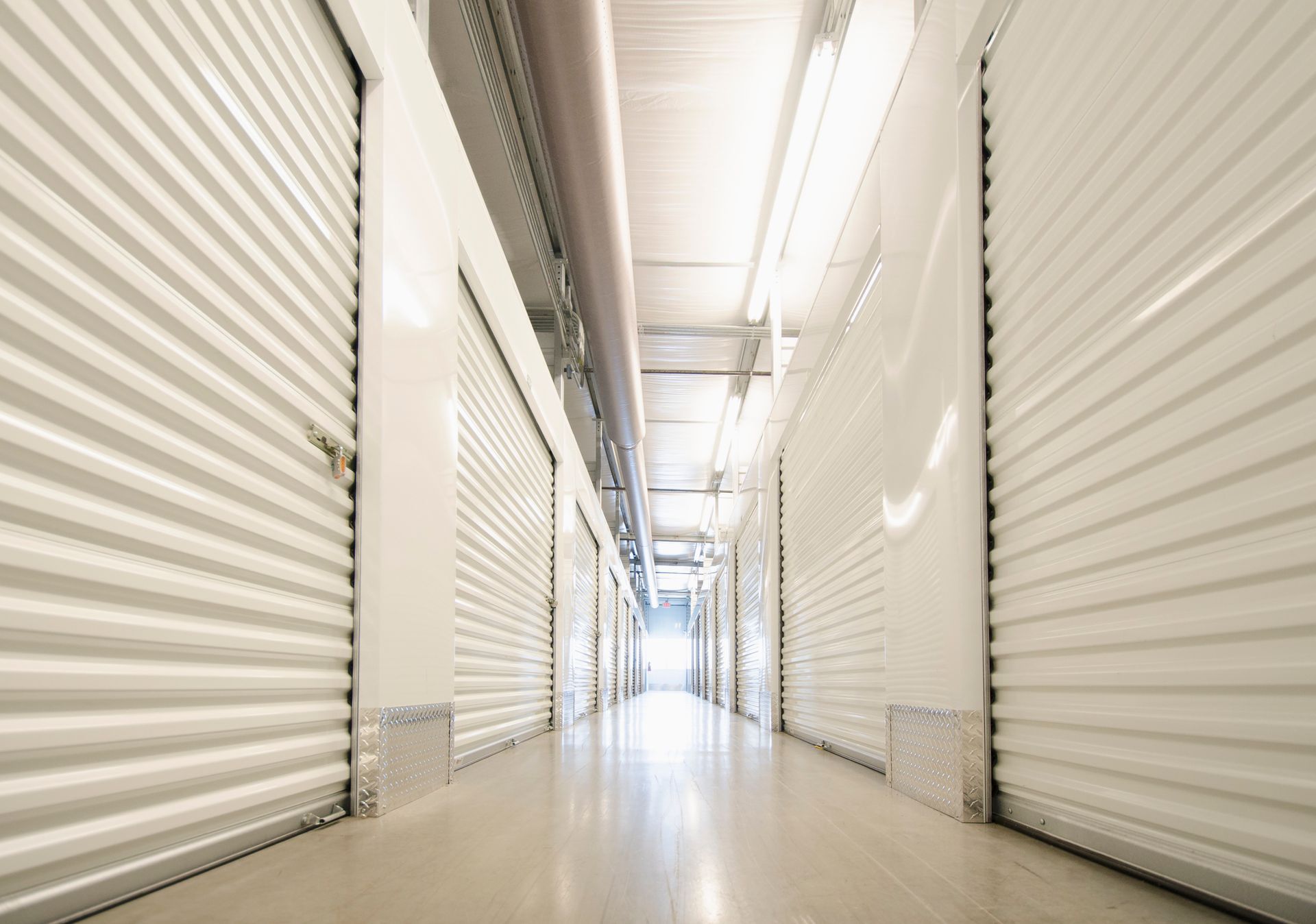 A clean, organized row of secure self-storage units with closed doors and clear pathways.