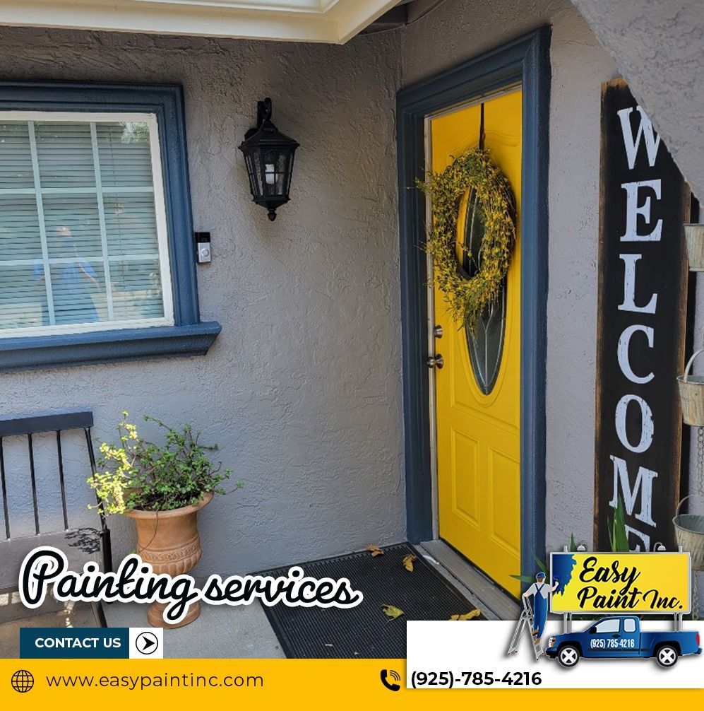 Exterior of a home with freshly painted gray stucco, blue trim, and a bright yellow door with a wreath.