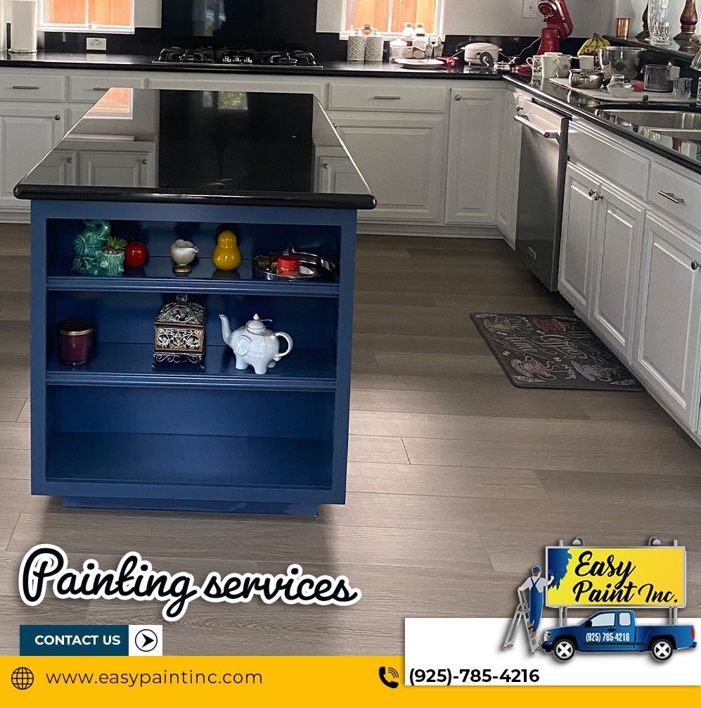 Kitchen with a blue island and white cabinets. 