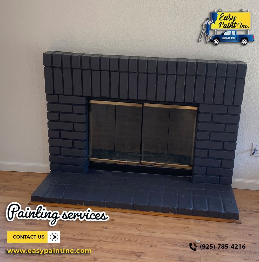 Dark gray painted brick fireplace with glass doors, and the company logo in the corner.