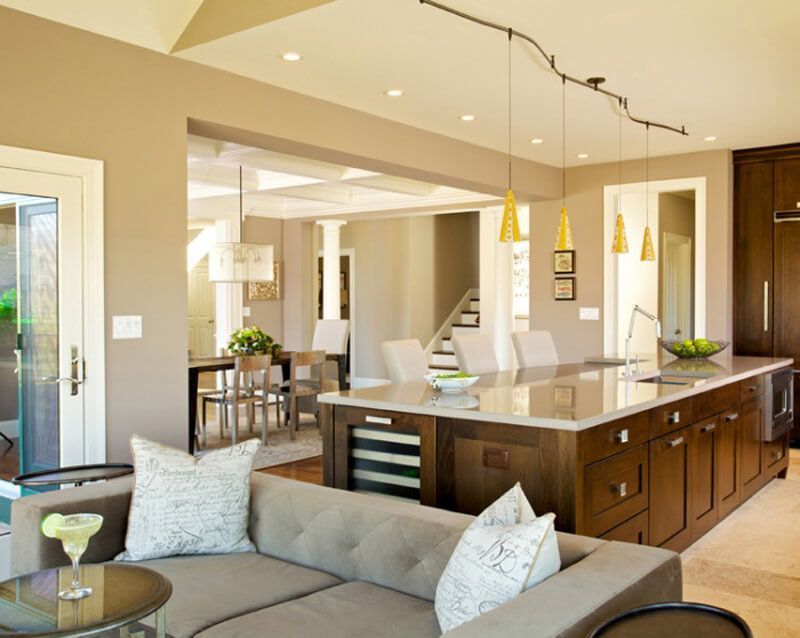 Modern kitchen with dark wood island, seating area, and dining space.