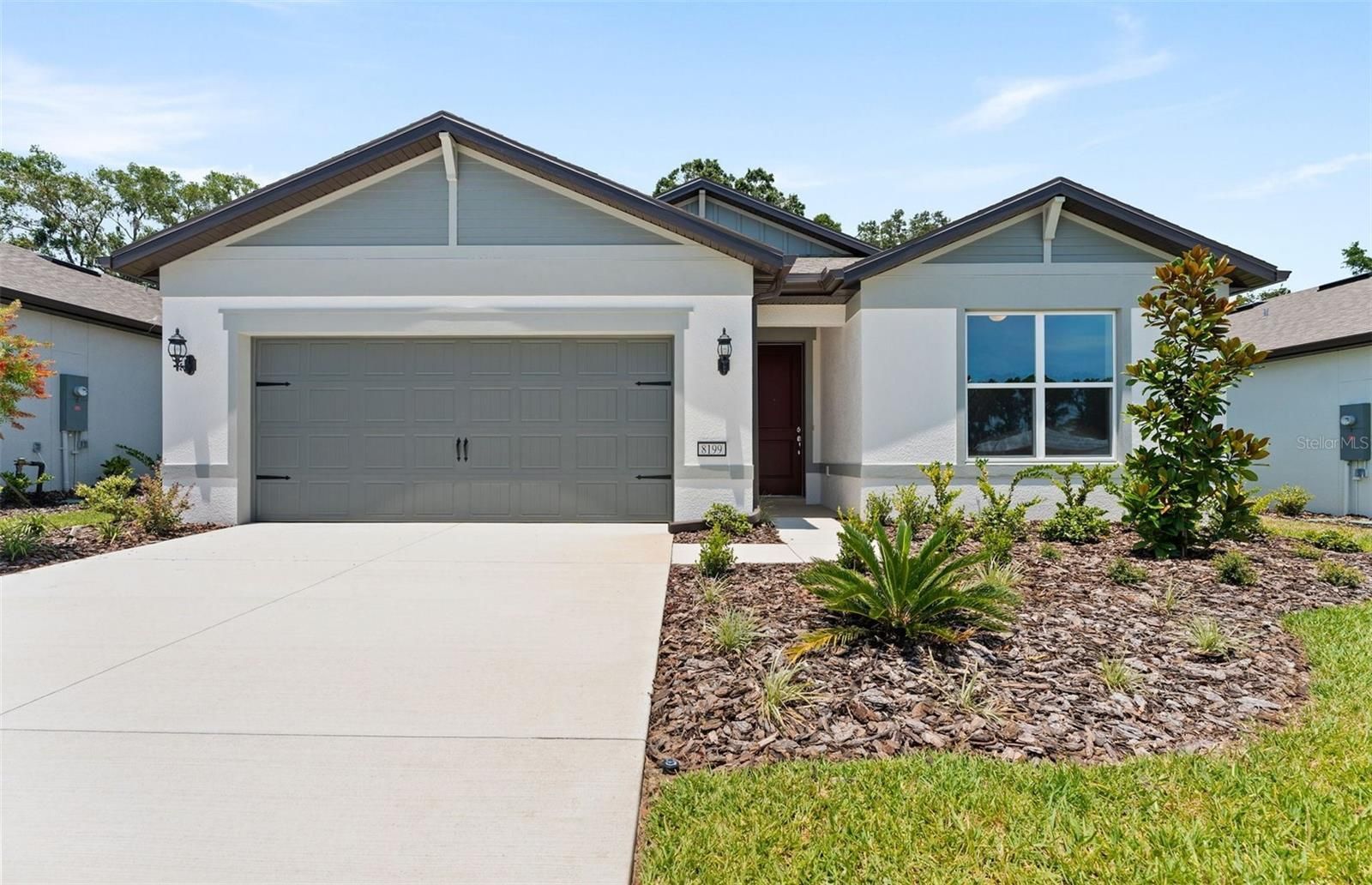Bright, white kitchen with island, stainless steel appliances, and hardwood floors.