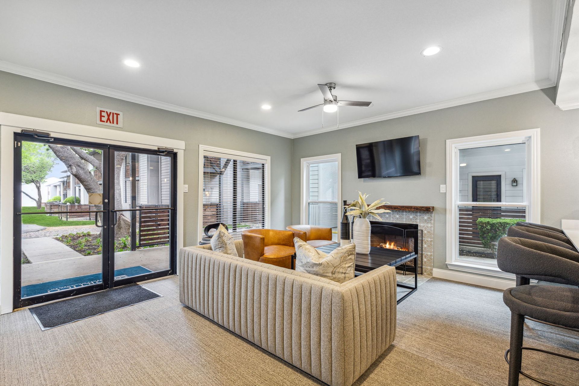 Cozy room with a couch, fireplace, TV, and large windows.