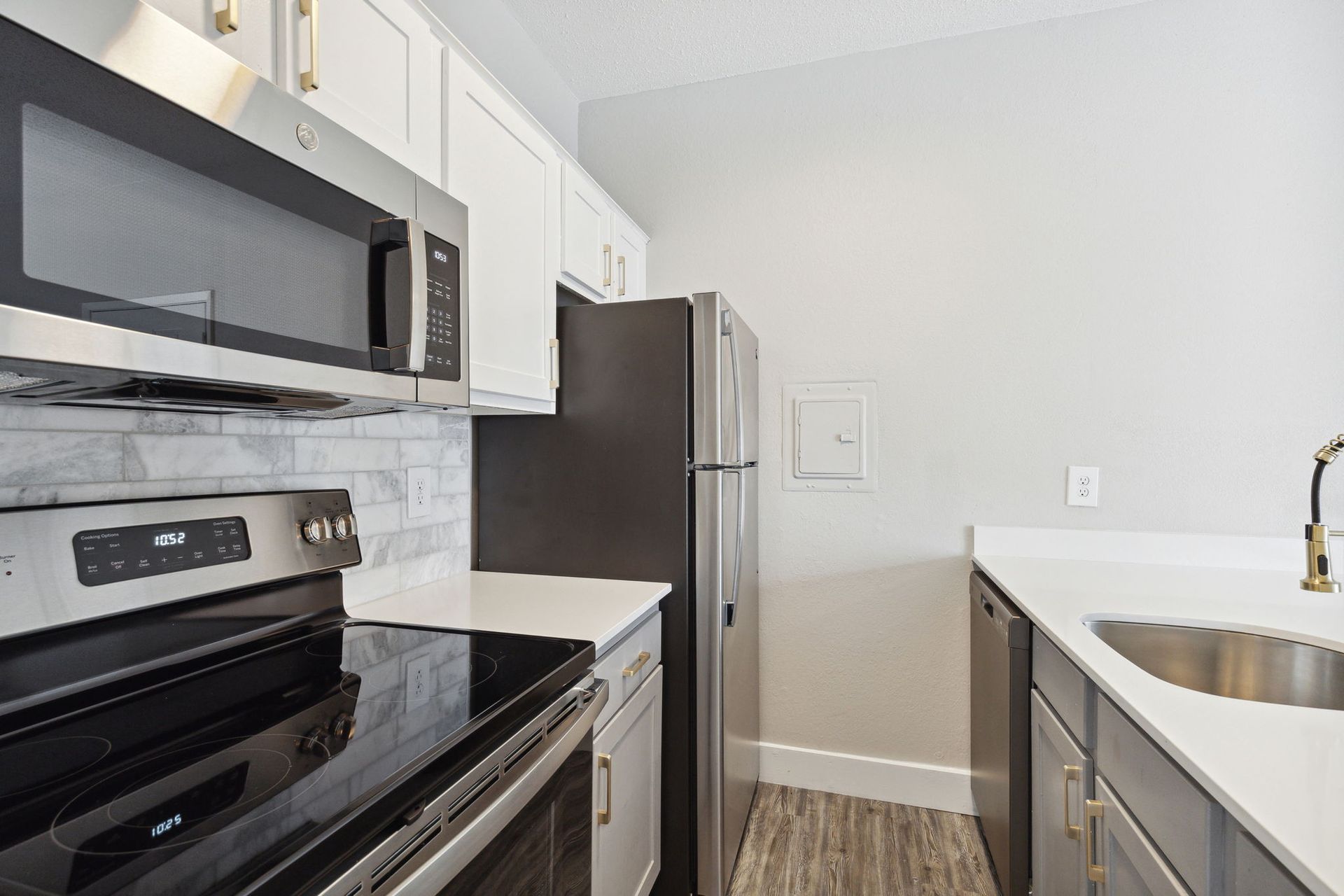 Kitchen with white cabinets, stainless steel appliances, and light countertops.
