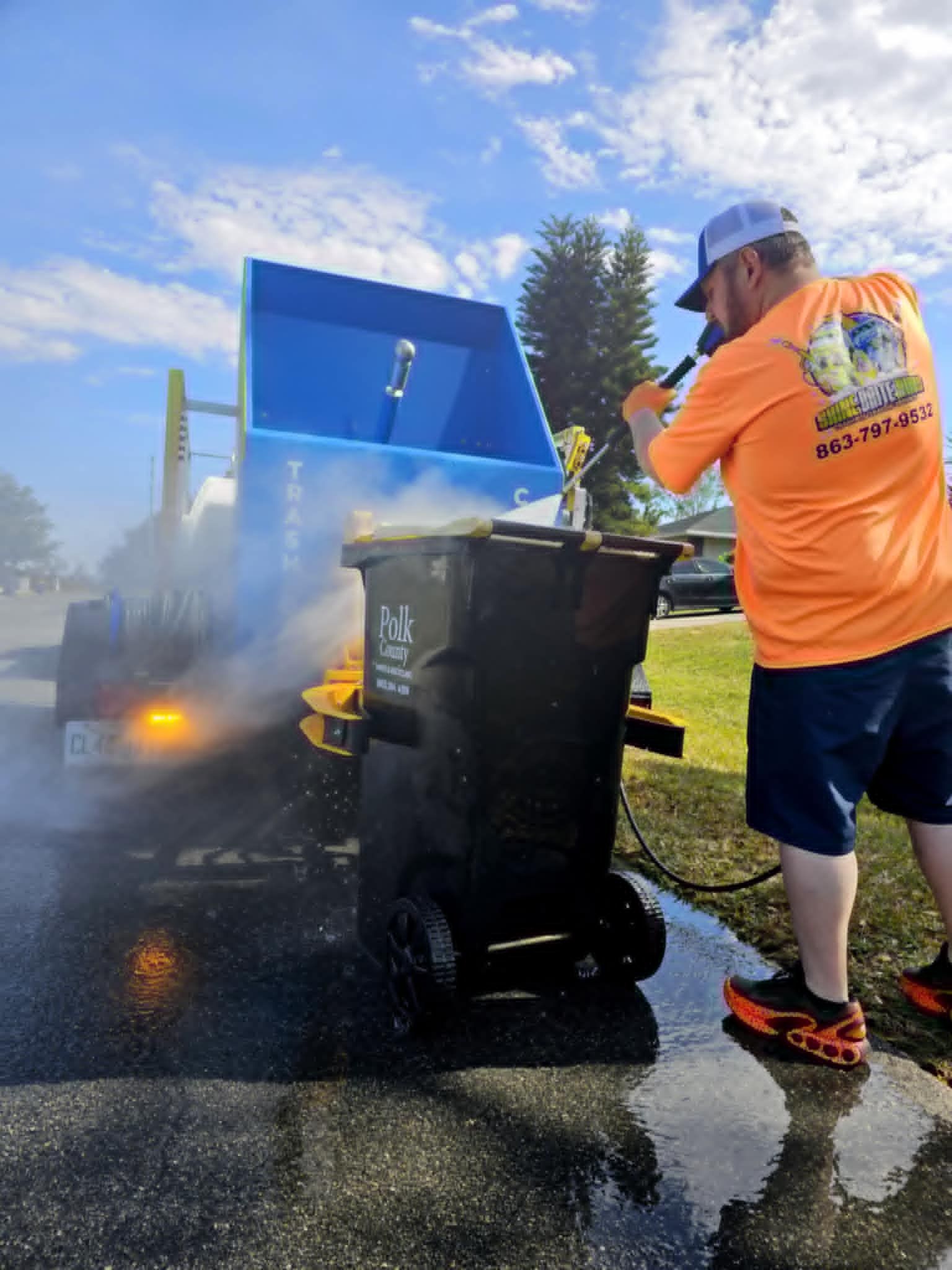 A man is standing in front of a garbage truck