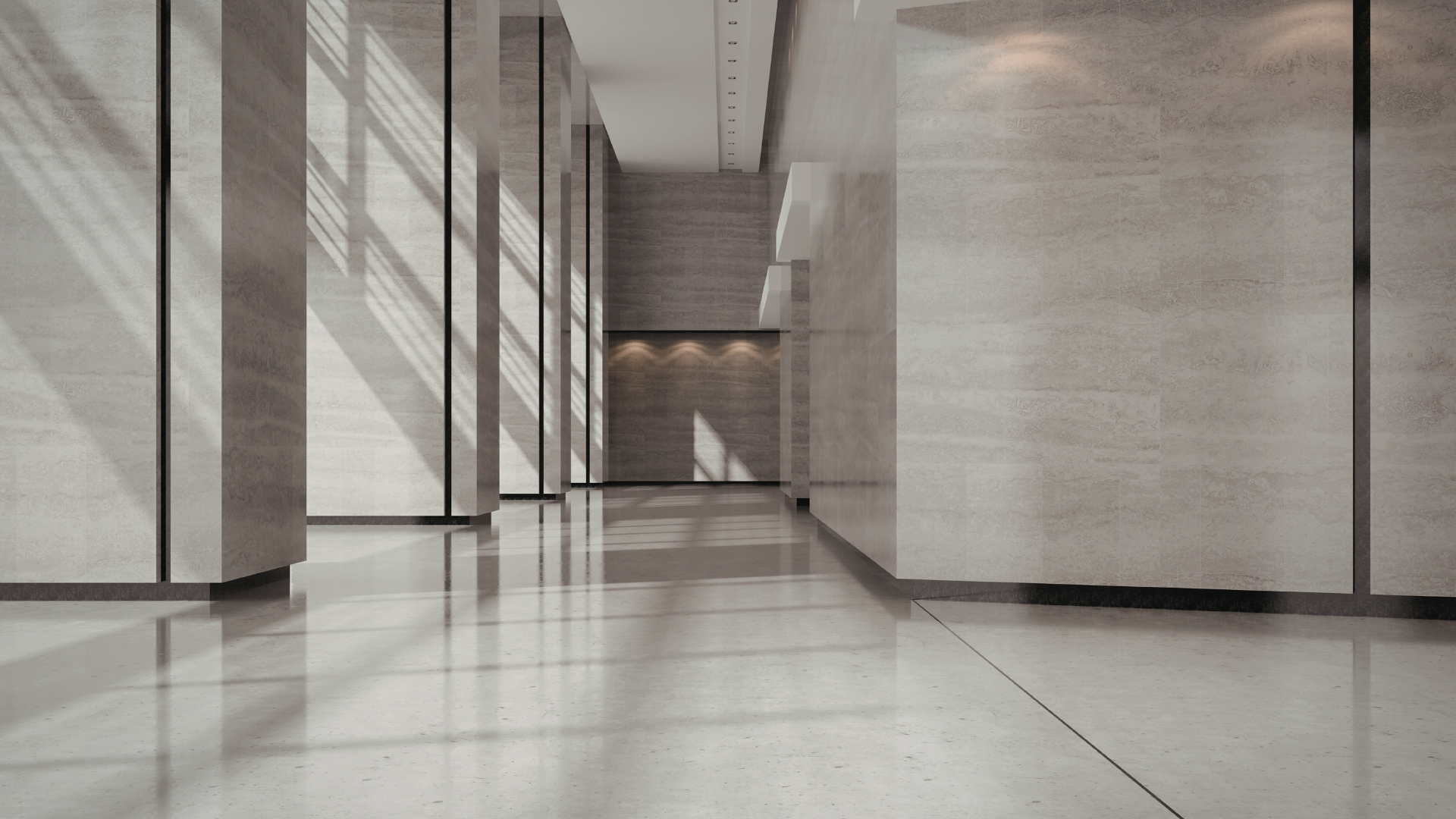 A modern, minimalist hallway with gray stone walls, reflective polished floors, and dramatic light beams from tall windows.