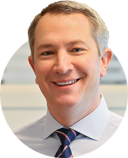 a man in a striped shirt and tie is smiling for the camera .