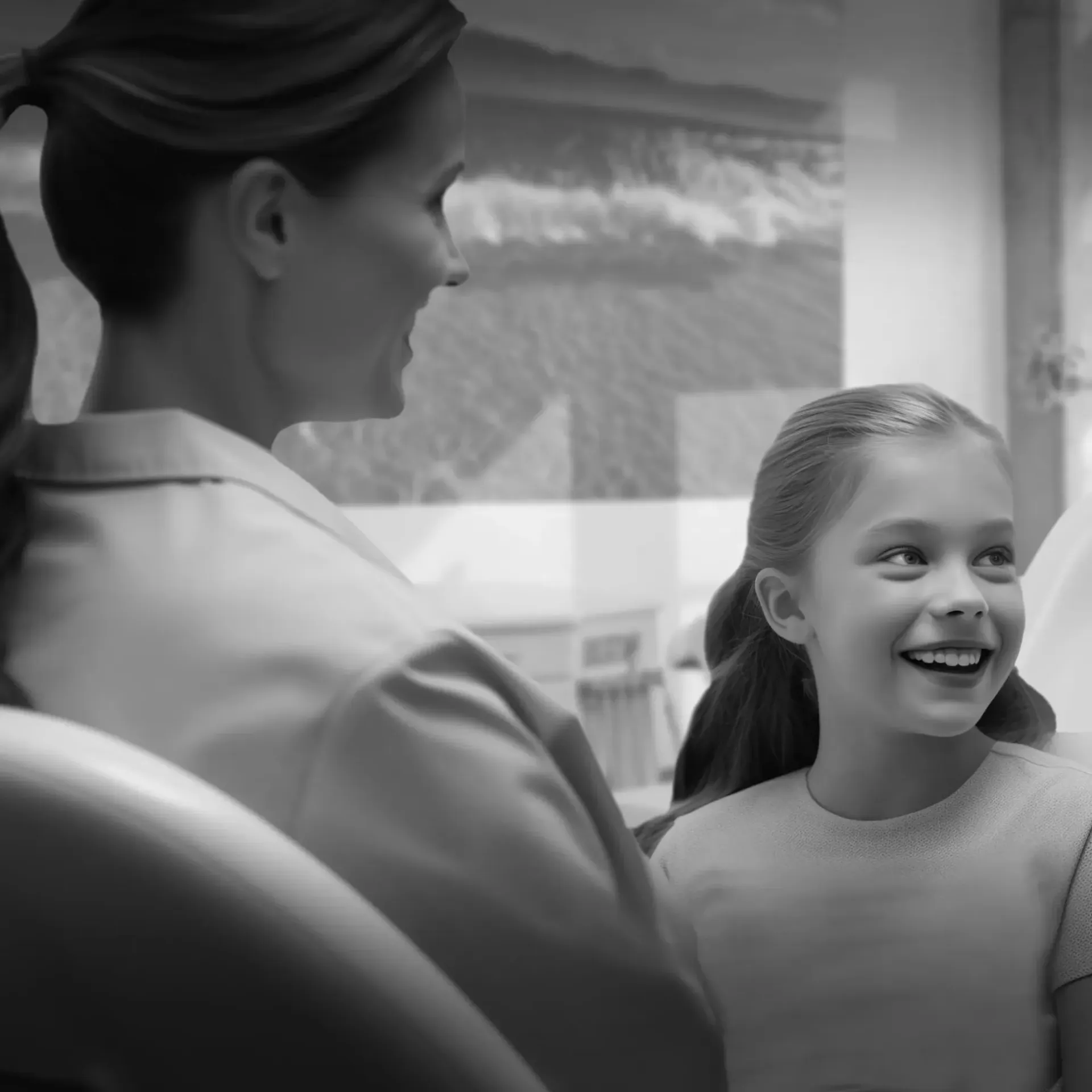 a woman is talking to a little girl in an orthodontic chair