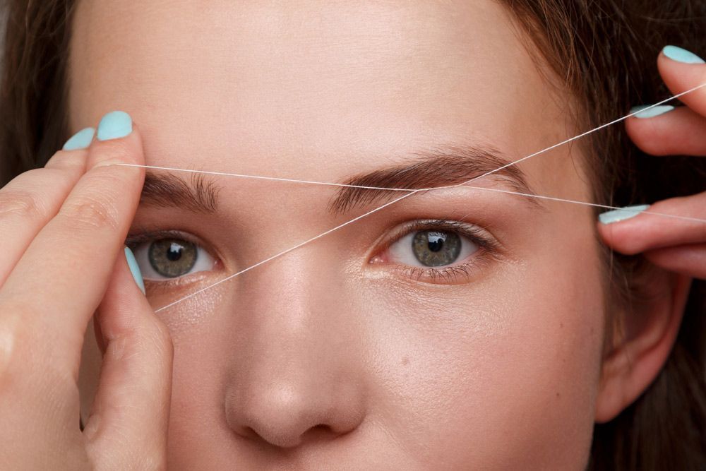Woman Getting Her Eyebrows Threaded With A String — Paradiso Skin & Beauty Studio in Byron Bay, NSW