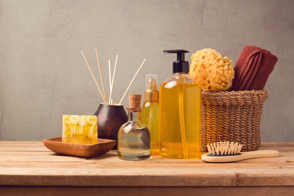 Wooden Table Topped With Bottles Of Soap And Sponges For Spa — Paradiso Skin & Beauty Studio in Byron Bay, NSW